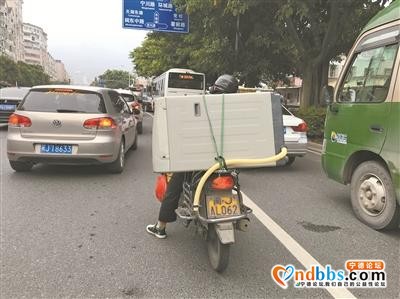 一名男子驾驶两轮车放着一架洗衣机在机动车道内随意穿行-1.jpg